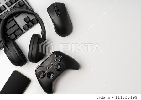 Top view of gamer table with computer keyboard, joystick and headphones 111533199