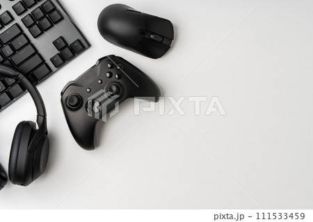 Top view of gamer table with computer keyboard, joystick and headphones 111533459