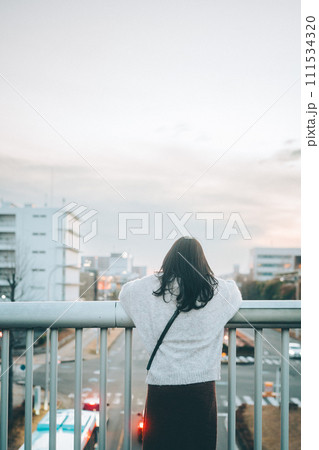 歩道橋から街中と夕焼けを見る女の子 歩道橋から街中と夕焼けを見る女の子 111534320