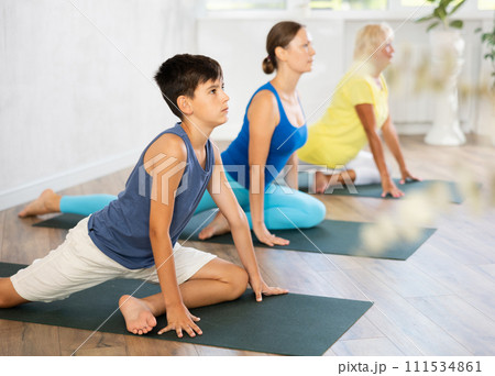 Group of people perform pigeon asana Group of people perform pigeon asana 111534861