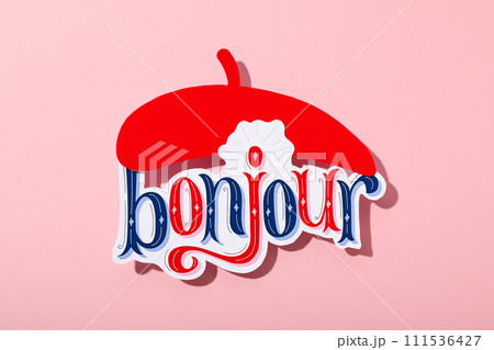 The word "bonjour" with a beret on a pink background. 111536427