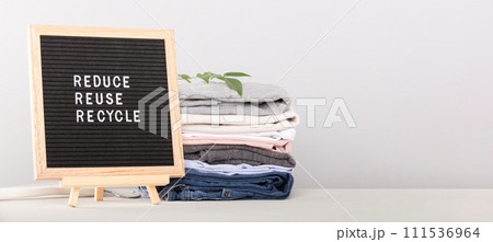 Black letter box with eco friendly motivational quote and A stack of clothes 111536964