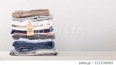 stack of folded clothes, grey background 111536965