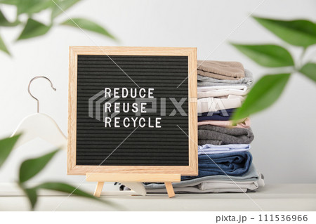 Black letter box and stack of folded clothes, reduce,reuse,recycle quote 111536966