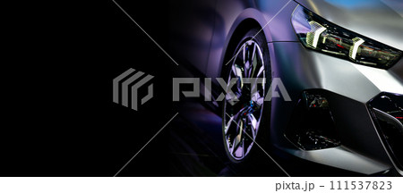 Front view of headlights modern sport car on black background, free space on left side for text Front view of headlights modern sport car on black background, free space on left side for text 111537823