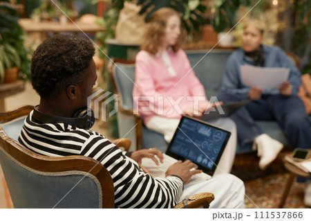 Over shoulder view of Black young man using laptop in coworking room and reviewing tech data on screen copy space 111537866