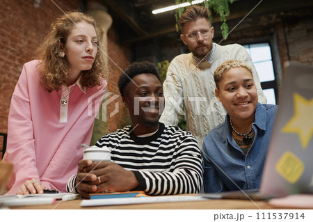 Low angle view at diverse young business team looking at computer screen during meeting in coworking space 111537914