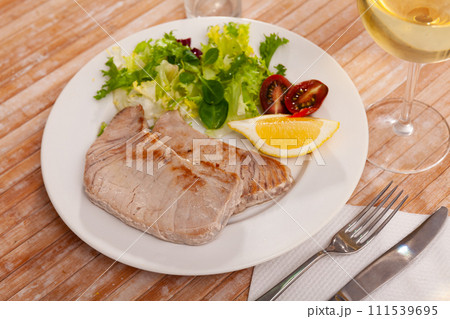 Fried tuna steaks with fresh lettuce, tomatoes and lemon Fried tuna steaks with fresh lettuce, tomatoes and lemon 111539695