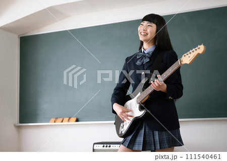ギターを演奏しながら歌う学生　吹奏楽や軽音楽の部活イメージ 111540461