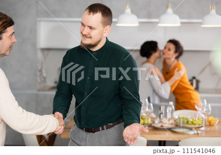 In home, male friends shake hands, say goodbye after socializing and gatherings. In home, male friends shake hands, say goodbye after socializing and gatherings. 111541046