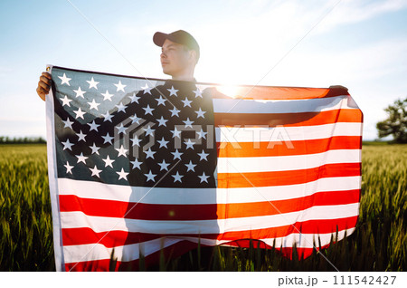 Man hold waving american USA flag. Patriot raise national american flag. Independence Day, 4th July. 111542427