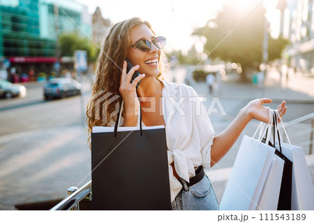 Beautiful woman with shopping bags makes selfie. Young woman walking shopping. Lifestyle concept. 111543189