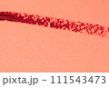Red lipstick stroke on a red background close-up macro photography. 111543473