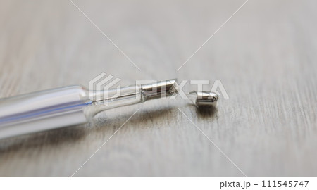 Broken mercury thermometer on a gray background, blurry Broken mercury thermometer on a gray background, blurry 111545747