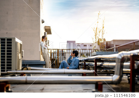 屋上で話す男女 111546100