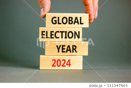 Global election year 2024 symbol. Concept words Global election year 2024 on beautiful block. Beautiful grey table grey background. Voter hand. Business Global election year 2024 concept. Copy space. 111547603