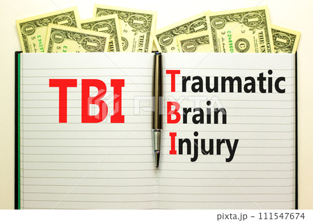 TBI traumatic brain injury symbol. Concept words TBI traumatic brain injury on white note on a beautiful background from dollar bills. Pen. Medical and TBI traumatic brain injury concept. Copy space 111547674