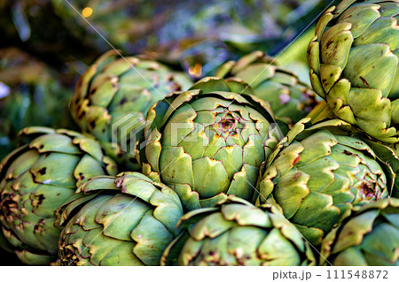 Bunch of green artichokes sitting on top of each other 111548872