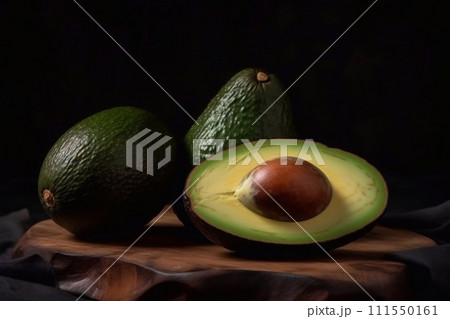 Avocado on wooden table. Cut avocados in wood bowl. Fresh green avocado Avocado on wooden table. Cut avocados in wood bowl. Fresh green avocado 111550161