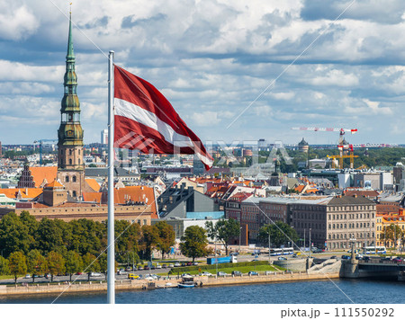 Beautiful Latvian flag flutters on wind with Riga old town in the background in Latvia. Patriotic video. Panoramic view. Beautiful Latvian flag flutters on wind with Riga old town in the background in Latvia. Patriotic video. Panoramic view. 111550292