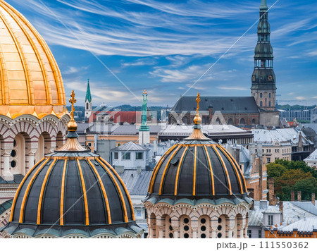 The Nativity of Christ Cathedral in Riga, Latvia. Byzantine-styled Orthodox cathedral, the largest in the Baltic region, with golden colored dome, polished gilded cupolas gleaming through the trees 111550362