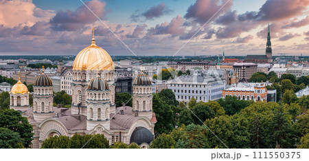 The Nativity of Christ Cathedral in Riga, Latvia. Byzantine-styled Orthodox cathedral, the largest in the Baltic region, with golden colored dome, polished gilded cupolas gleaming through the trees 111550375