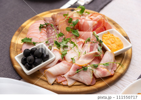 Delicious meat platter - sliced dry-cured jamon, bacon, chorizo and salami 111550717