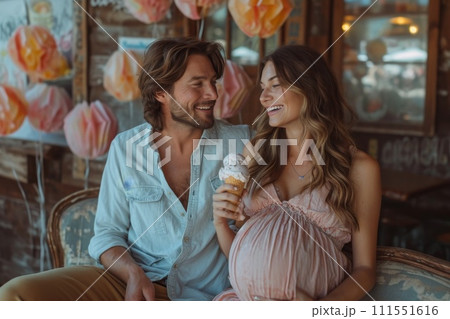 A pregnant girl is sitting with her husband on the couch at home with ice cream 111551616