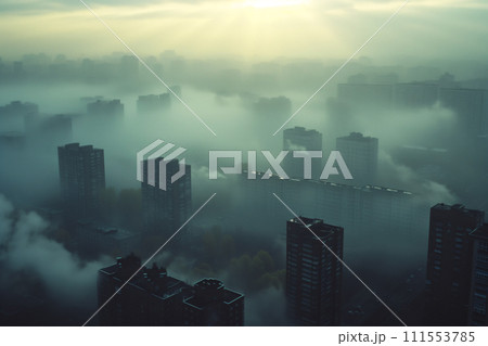 Early morning view of a city enveloped in dense fog with sunrays cutting through, highlighting the silhouettes of high-rise buildings. 111553785