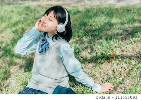 屋外で音楽を聴く女子高生 111555093