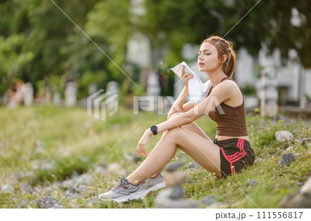 Happy slim woman wearing sportswear in the garden at sunrise. Young beautiful asian female in sports bra running outdoor. Workout exercise in the morning. Healthy and active lifestyle concept. Happy slim woman wearing sportswear in the garden at sunrise. Young beautiful asian female in sports bra running outdoor. Workout exercise in the morning. Healthy and active lifestyle concept. 111556817