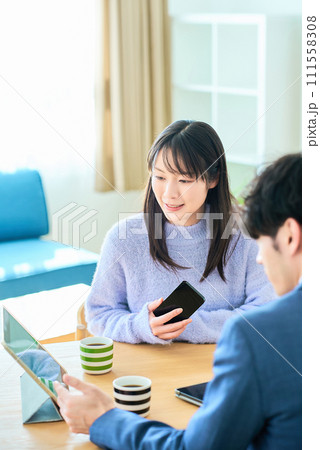 スーツ姿の男性の話を聞く若い女性 111558308