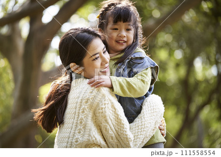 asian mother and daughter hugging outdoors asian mother and daughter hugging outdoors 111558554