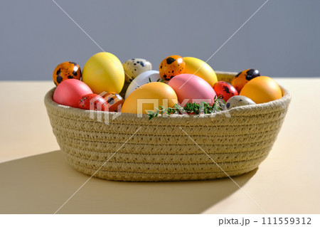Easter colored eggs in a wicker basket. Easter composition. 111559312
