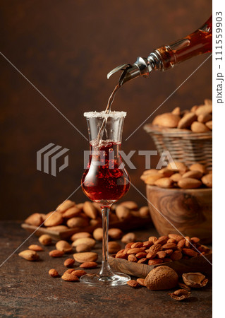 Italian liqueur Amaretto with almonds nuts on a wintage table. 111559903