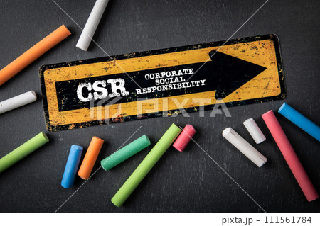 Corporate Social Responsibility. Direction arrow with text on a dark chalkboard background Corporate Social Responsibility. Direction arrow with text on a dark chalkboard background 111561784