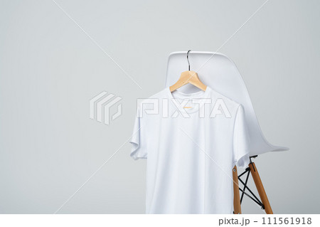 White blank t-shirt hanging on chair in empty room 111561918