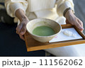 抹茶を持っている女性 111562062