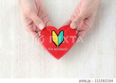 初心者マークの付いたハートのオブジェクトを持つ人物の手元 111562104