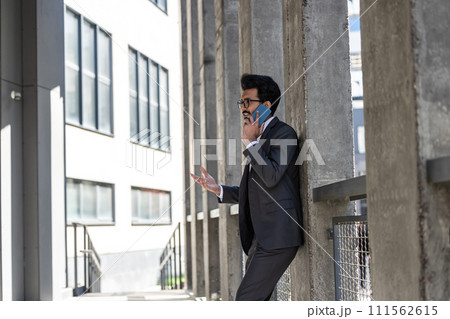 Stylish young businessman in office area with a phone in hands 111562615