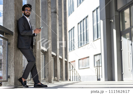 Stylish young businessman in office area with a phone in hands 111562617