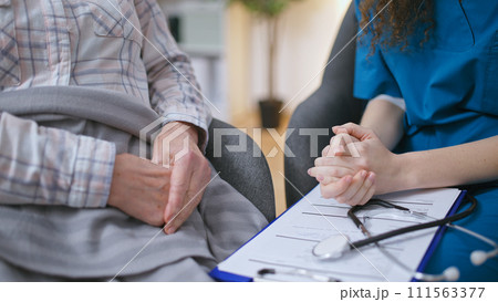 Close-up of hands of young doctor and mature patient, concept of care and support Close-up of hands of young doctor and mature patient, concept of care and support 111563377