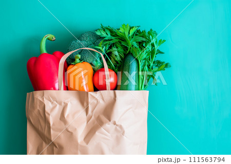 Craft brown shopping paper bag and grocery on blue background. Delivery concept Craft brown shopping paper bag and grocery on blue background. Delivery concept 111563794