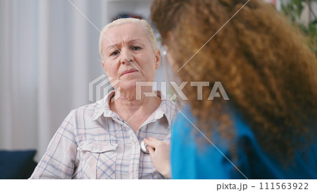 Emergency doctor listening to heartbeat of an unhealthy woman, risk of heart attack 111563922