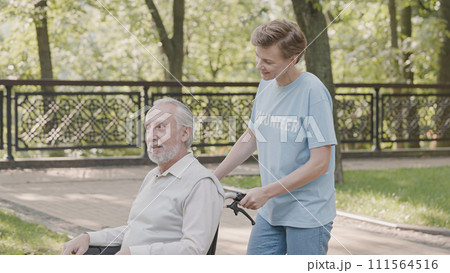 Woman volunteer taking care of elderly man with disability at retirement home, kindness Woman volunteer taking care of elderly man with disability at retirement home, kindness 111564516