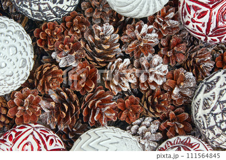 New Year frame made of frosted pine cones and Christmas balls. Christmas decor top view New Year frame made of frosted pine cones and Christmas balls. Christmas decor top view 111564845