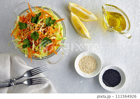 Healthy vegetable salad of cabbage and carrots garnished with parsley and cumin and sesame seeds and dressed with olive oil and lemon Healthy vegetable salad of cabbage and carrots garnished with parsley and cumin and sesame seeds and dressed with olive oil and lemon 111564926