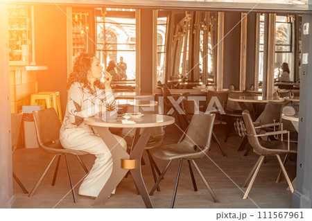Woman cafe coffee breakfast. Portrait of an adult beautiful woman in an elegant suit in a cafe Woman cafe coffee breakfast. Portrait of an adult beautiful woman in an elegant suit in a cafe 111567961