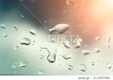 Water drops on glass against blue sky, rainy season concept. Window view background screensaver 111567992
