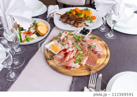 Delicious meat platter - sliced dry-cured jamon, bacon, chorizo and salami 111569591